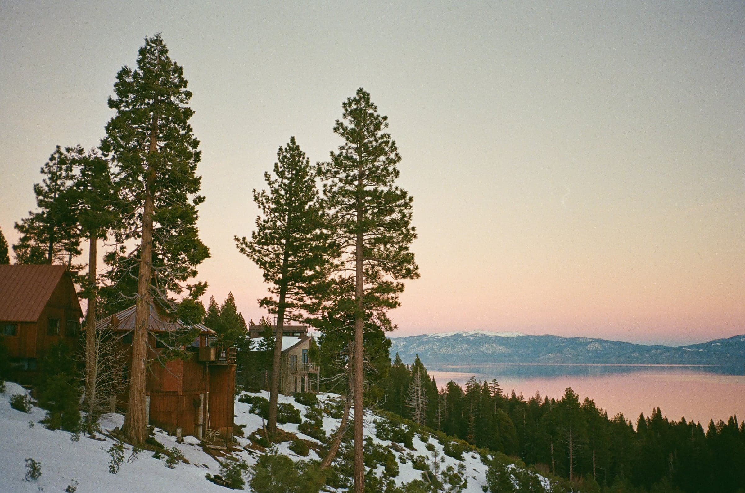 Pink sunset over a snowy mountain lake