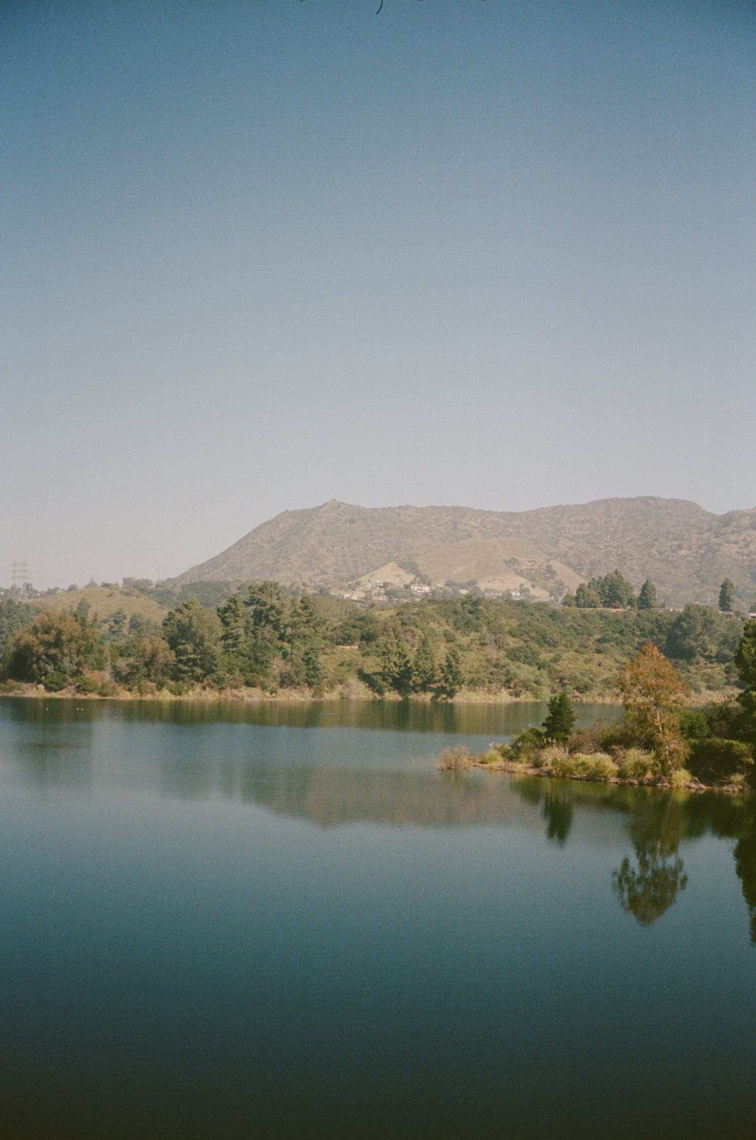 Still lake beneath a hazy mountain